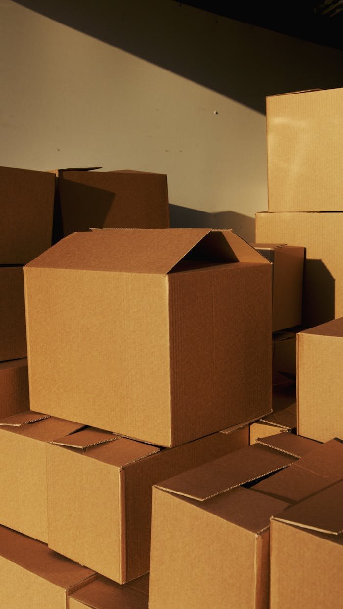 Home Stacked cardboard boxes ready for shipping or storage in a warehouse setting.