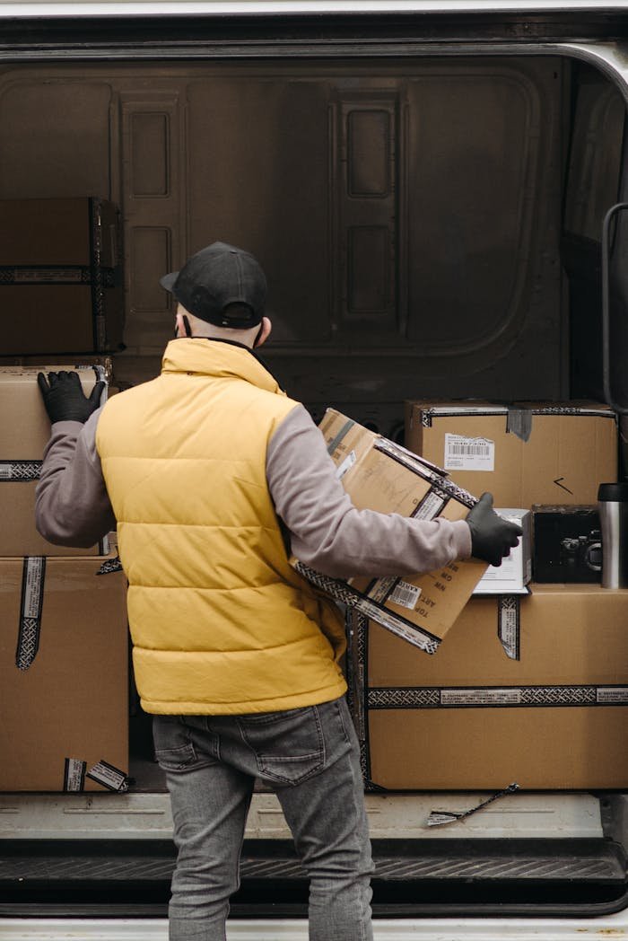 Services Deliveryman organizing packages into a van for distribution.